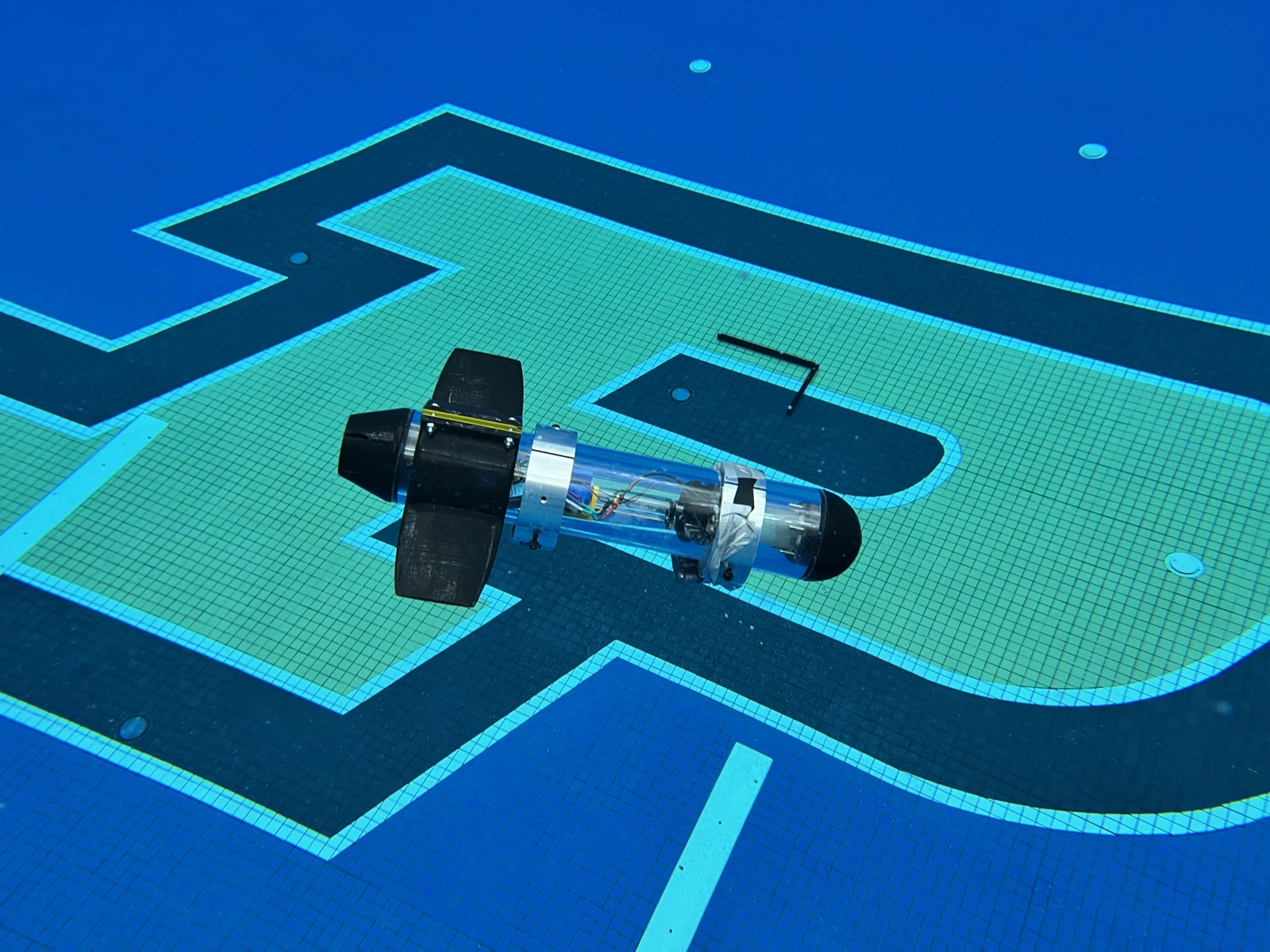 Transparent-hull mini-ROUGHIE prototype underwater above the pool floor